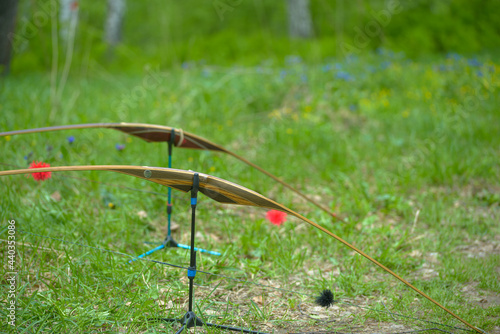 professional archer shooting with modern longbow on road in forest 