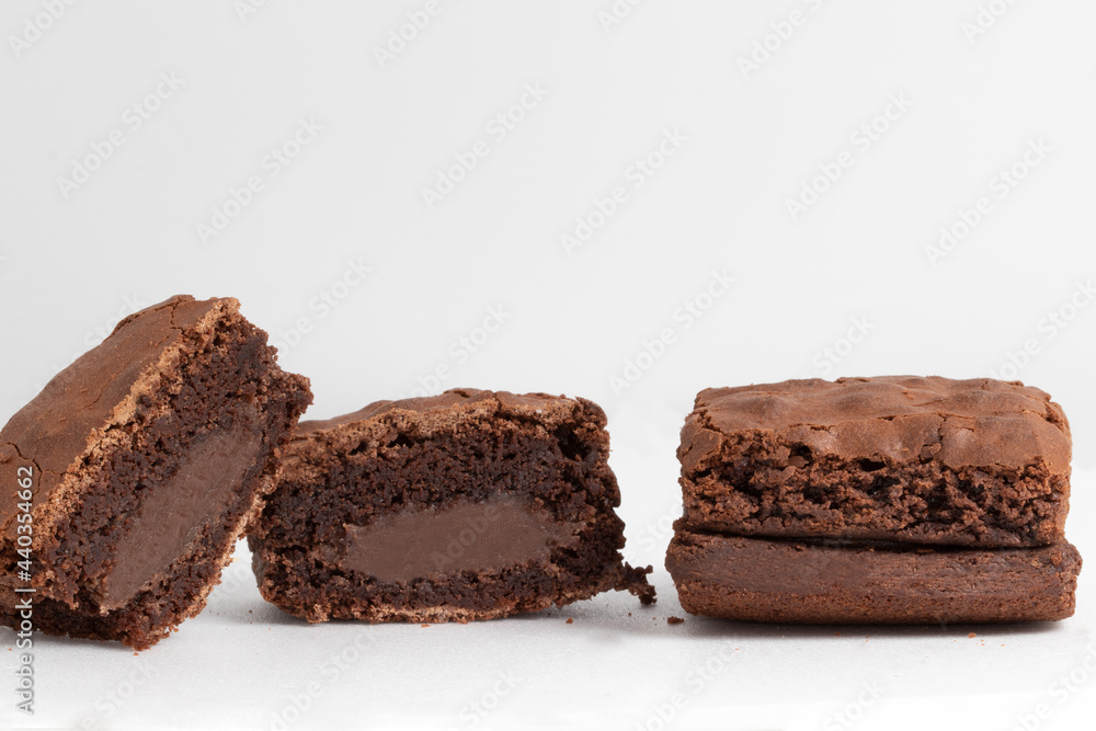 Whole and halves brownies stuffed with chocolate on white background. Whole and halves brownies stuffed with chocolate on white background.