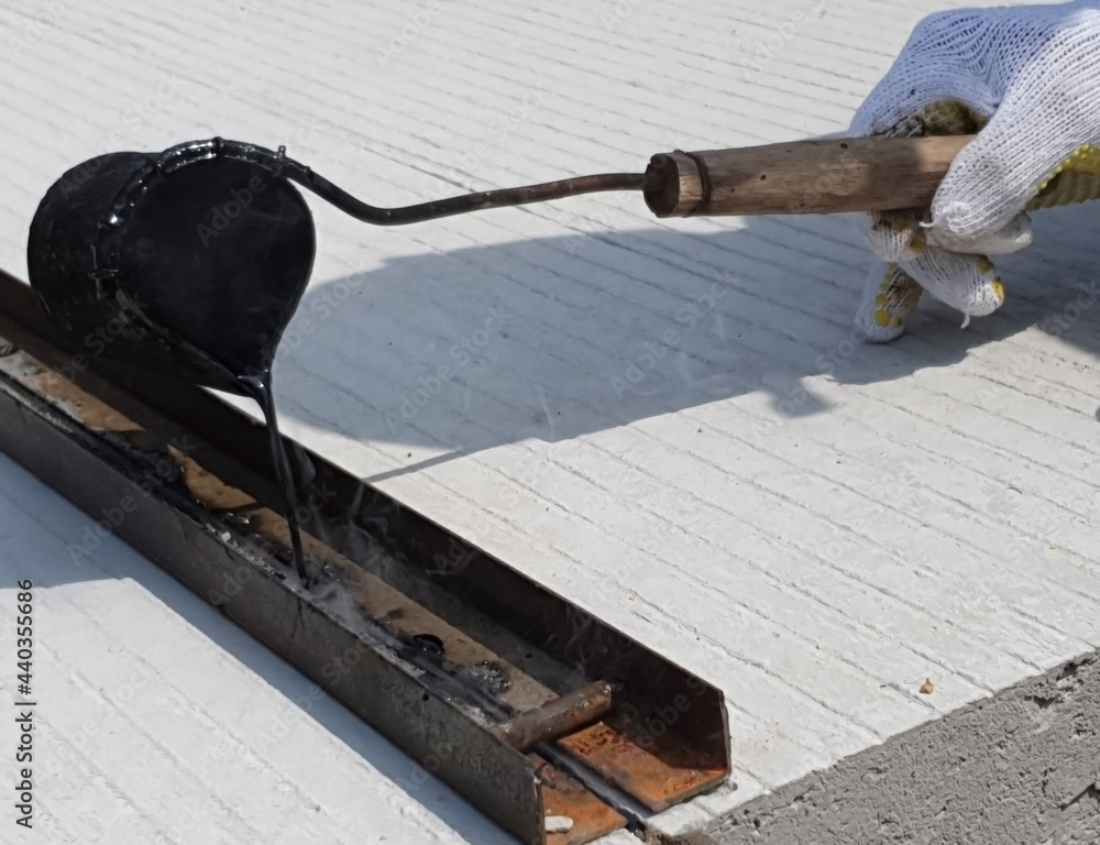 Obraz premium Filling the gaps between rigid pavement using hot asphalt in Serdang Bedagai, Indonesia on April 15, 2020.