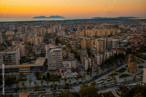 VLORA, ALBANIA: Cityscape seen from Kuzum Baba hill. Aerial city view, city panorama of Vlore at sunset. photo