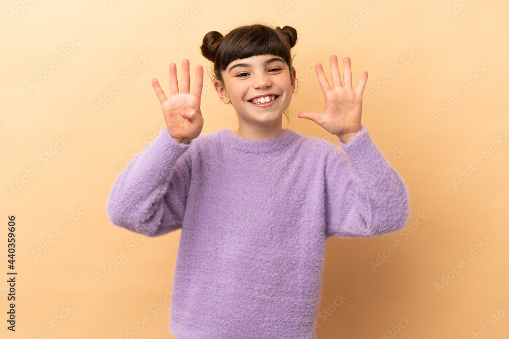 Little caucasian girl isolated on beige background counting nine with fingers Little caucasian girl isolated on beige background counting nine with fingers