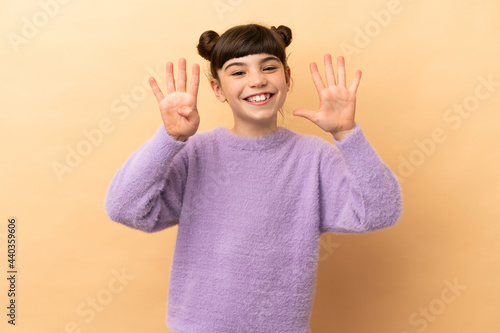 Little caucasian girl isolated on beige background counting nine with fingers