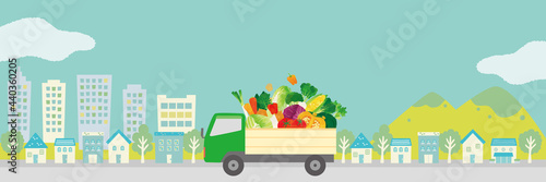 野菜を乗せたトラックと街並み　水彩タッチイラスト