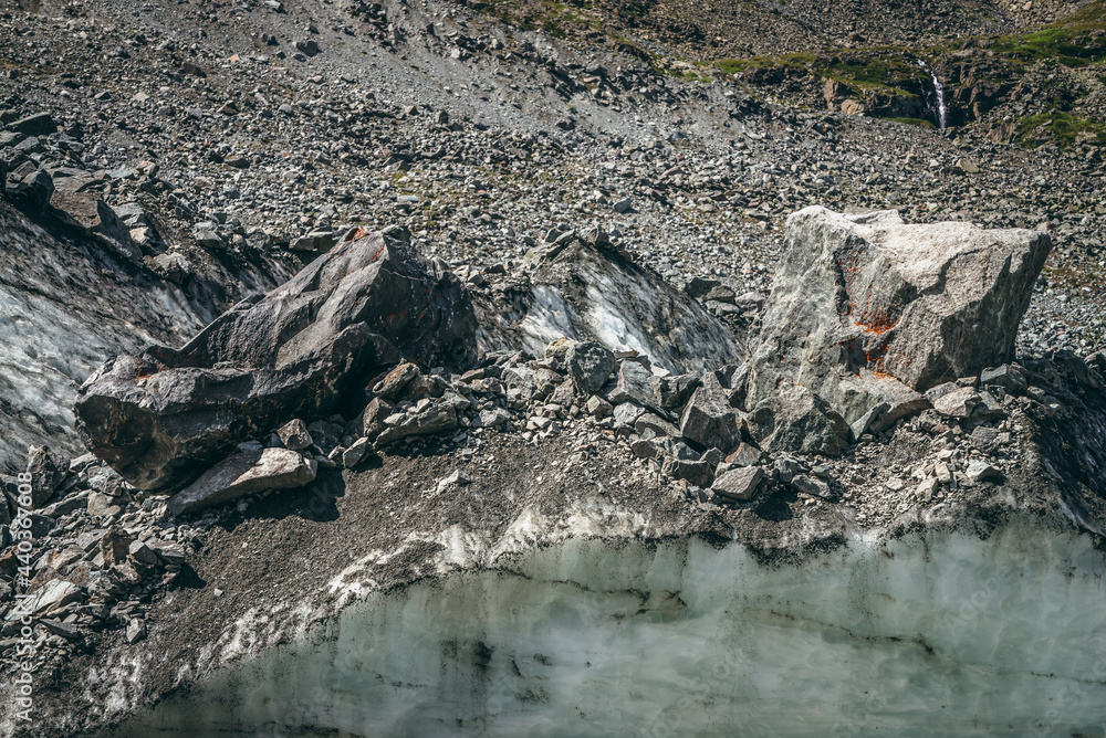 Nature background with icefall near glacier with cracks and scratches. Natural backdrop with icy wall and moraines. Beautiful landscape with shiny glacial wall and stones in sunlight. Glacier texture. Nature background with icefall near glacier with cracks and scratches. Natural backdrop with icy wall and moraines. Beautiful landscape with shiny glacial wall and stones in sunlight. Glacier texture.