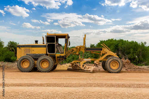 Grader Road Construction Grader industrial machine on construction of new roads. the blade of a motor grader in the process of leveling a sandy road foundation. Grader is working on road construction.