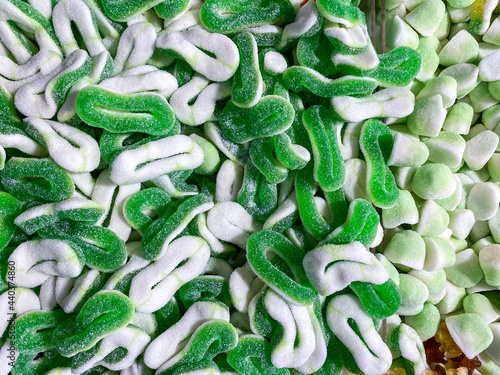 Green gummy candies and jellies as background. A lot of colorful jelly sweets