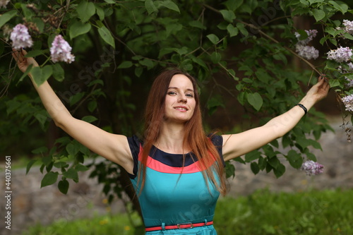 portrait of a woman against the background of lilac bushes