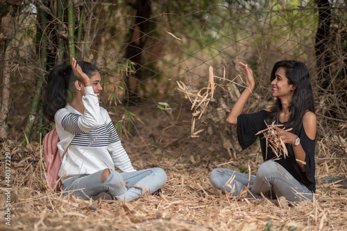 Happy girls playing with fallen leaves in park