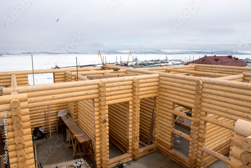 Construction of wooden house against the winter landscape