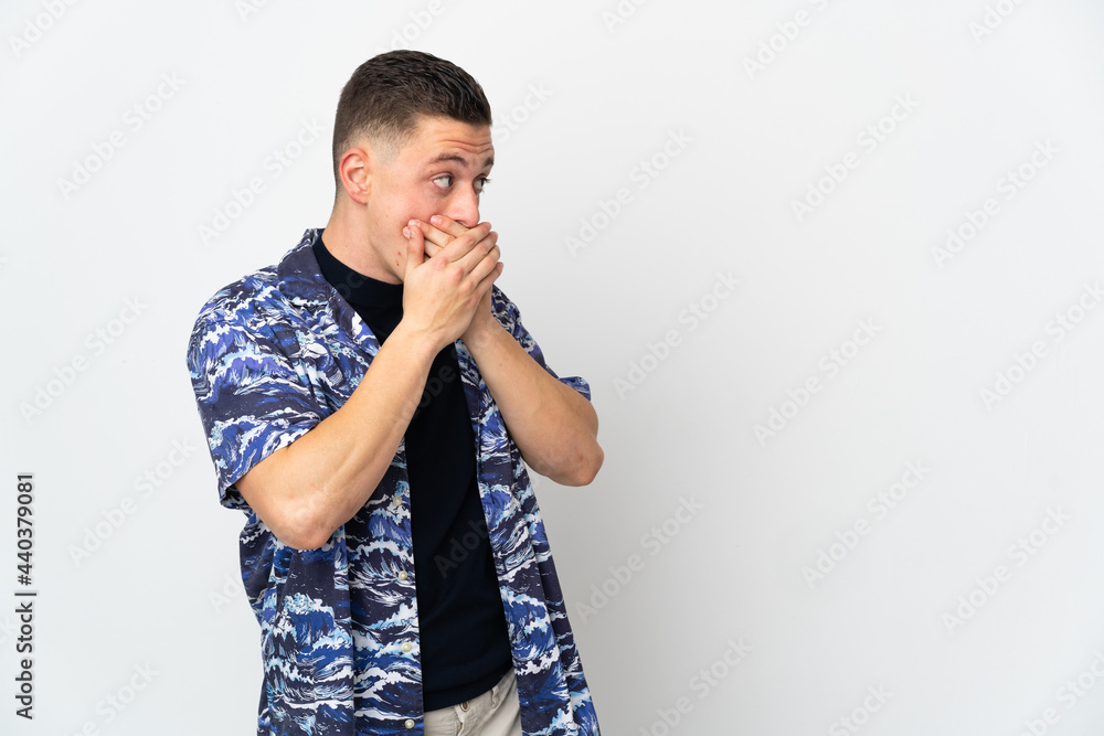 Young caucasian man isolated on white background covering mouth and looking to the side Young caucasian man isolated on white background covering mouth and looking to the side