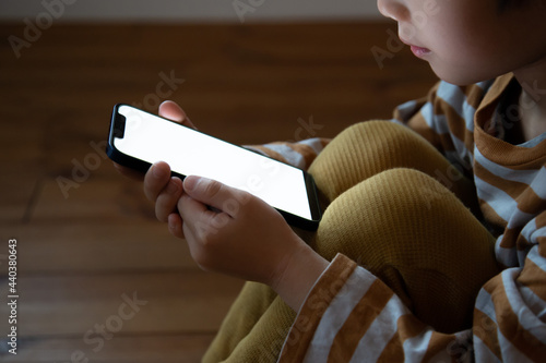 一人でスマートフォンを利用する子供