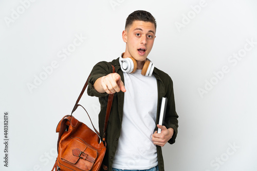 Young caucasian student man isolated on white background surprised and pointing front