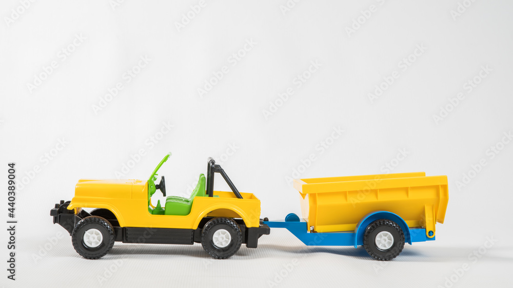 Plastic toy multicolored cars isolated on white background. SUV with a trailer. Plastic toy multicolored cars isolated on white background. SUV with a trailer.