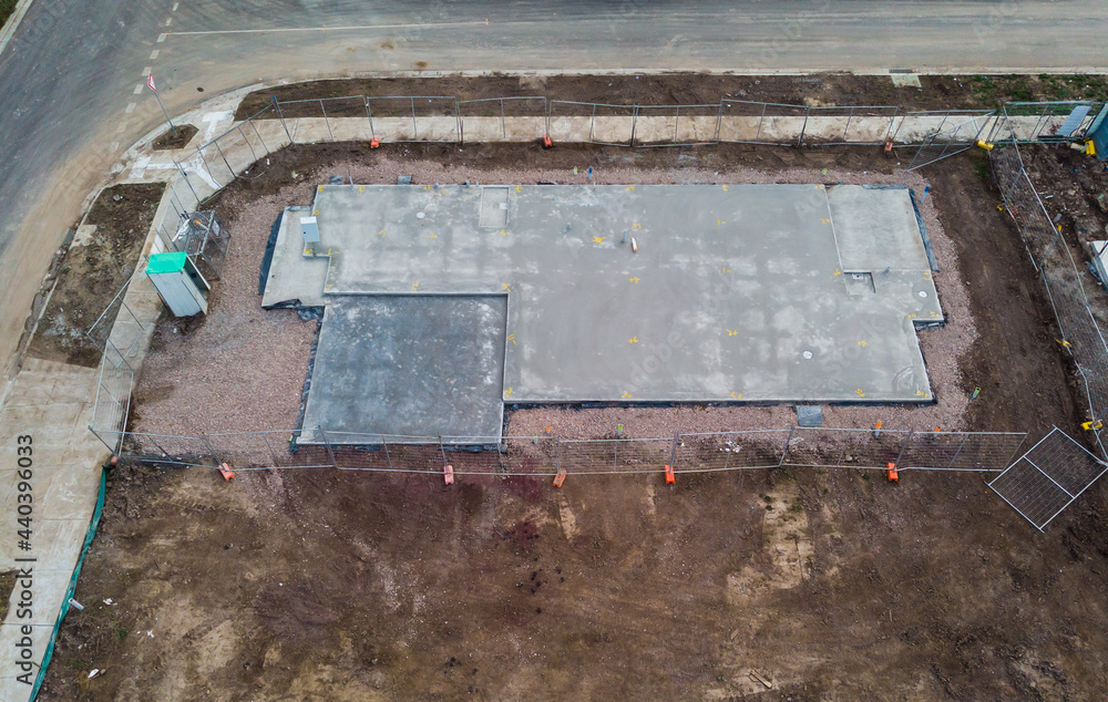 An aerial view of a freshly laid concrete house slab in a new