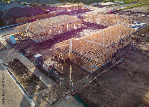 Sunset in the suburbs, houses at different stages of construction sit empty at the end of a day waiting for builders to return to complete their work so families can move in to these new houses.