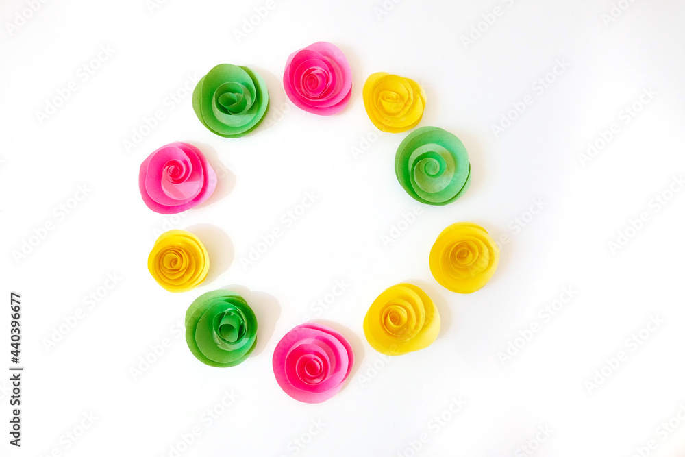 A circle of multi-colored paper homemade flowers, similar to roses. Isolated. Copy space. A circle of multi-colored paper homemade flowers, similar to roses. Isolated. Copy space.