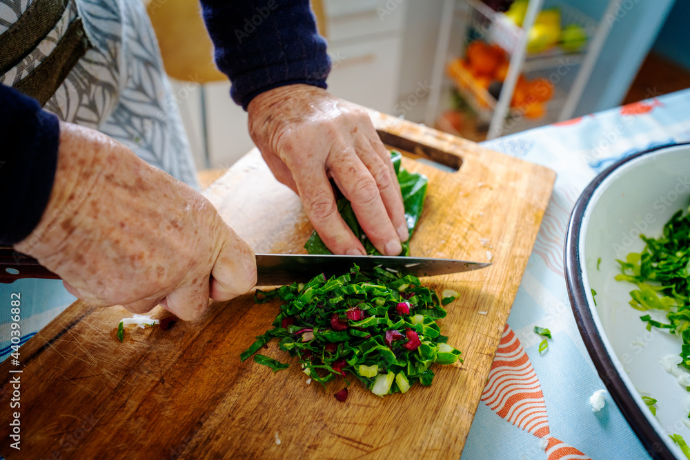 old woman preparing salad with a knife old woman preparing salad with a knife