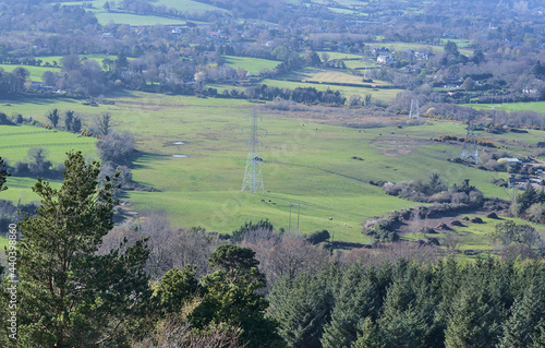 Beautiful bright aerial-like view of green fields, and high voltage electric line in rural south Dublin seen from Ballycorus Lead Mines on sunny day, Ballycorus, Co. Dublin, Ireland. High resolution