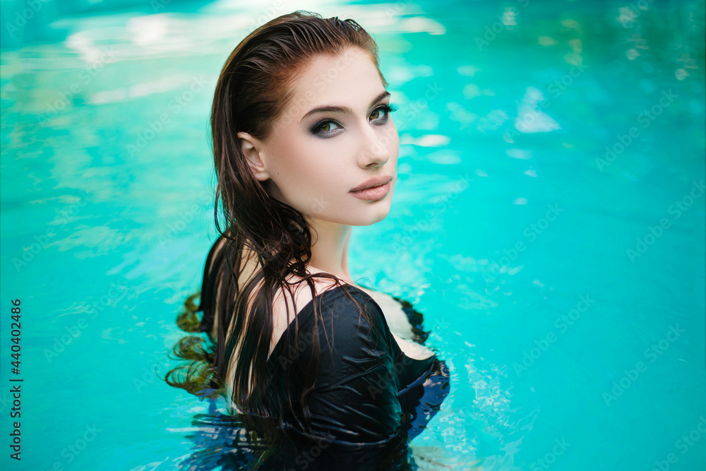 Beautiful girl with wet hair in a blue pool. Rest at home.