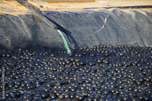 East Kazakhstan region, Kazakhstan - 12.02.2015 : The chemical tank is covered with plastic balls to slow evaporation at the copper cathode mining plant. photo