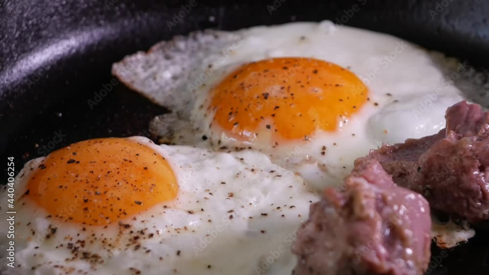 Simple men's food - egg with braised chunks of meat fried in a cast iron skillet Simple men's food - egg with braised chunks of meat fried in a cast iron skillet