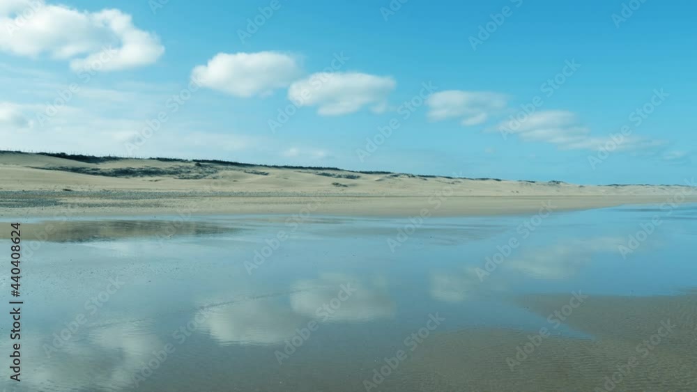 Empty beach with sand dunes, clouds and reflections in Essaouira. Relaxing tranquil nature scenery. Tourist destination of Morocco. Empty beach with sand dunes, clouds and reflections in Essaouira. Relaxing tranquil nature scenery. Tourist destination of Morocco.