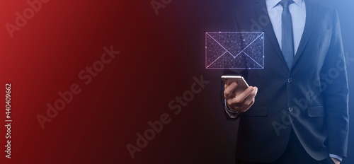 Businessman hand holding e-mail icon  Contact us by newsletter email and protect your personal information from spam mail. Customer service call center contact us concept