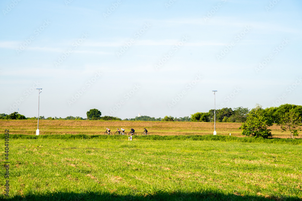 The landscape of unidentified group of people is cycling and biking along the green field at countryside city in Thailand in the morning. The famous Bike Lane in Thailand is located near the airport. The landscape of unidentified group of people is cycling and biking along the green field at countryside city in Thailand in the morning. The famous Bike Lane in Thailand is located near the airport.