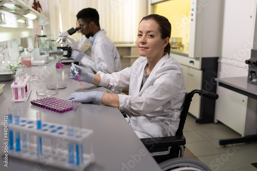Successful disable female scientist in wheelchair working in lab