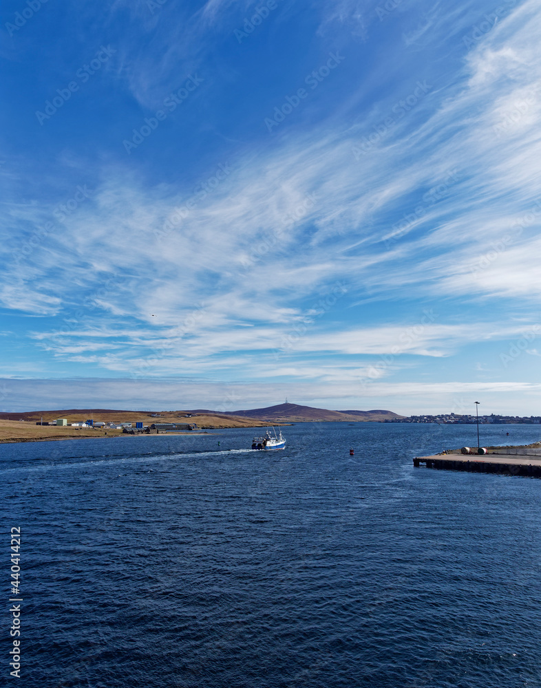 A Fishing Vessel heading into the Fishing Quay at Lerwick Harbour in sunny April Weather and calm water in Bressay sound.