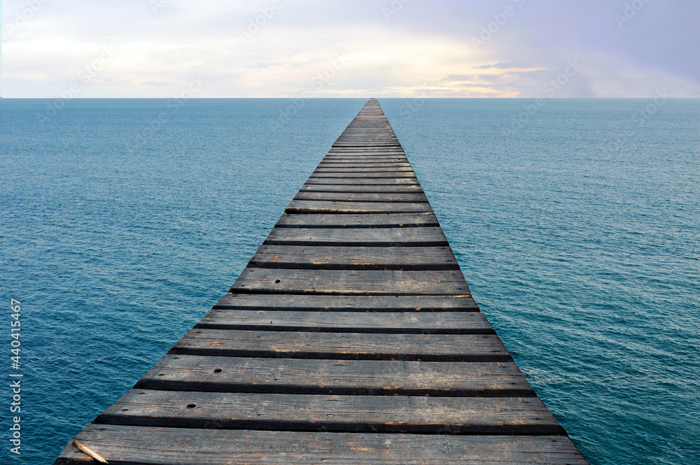 Fototapeta premium Stairway to the horizon. Conceptual. Photomontage with an old duckboard over the sea leading to the skyline.