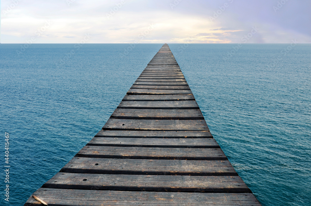 Stairway to the horizon. Conceptual. Photomontage with an old duckboard over the sea leading to the skyline.