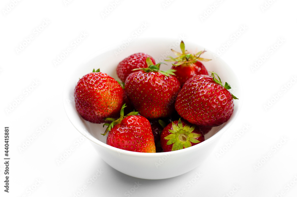 Ripe red strawberries in a white plate. Dessert. On white background. Ripe red strawberries in a white plate. Dessert. On white background.