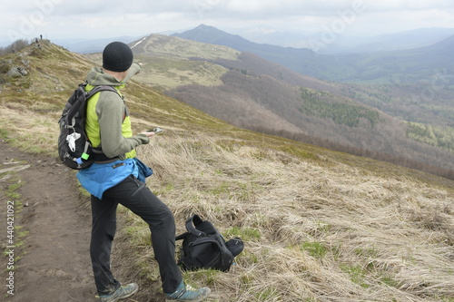 Fototapeta Naklejka Na Ścianę i Meble -  Hiking in Bieszczady mountain in spring. Adult  against the backdrop of mountains.