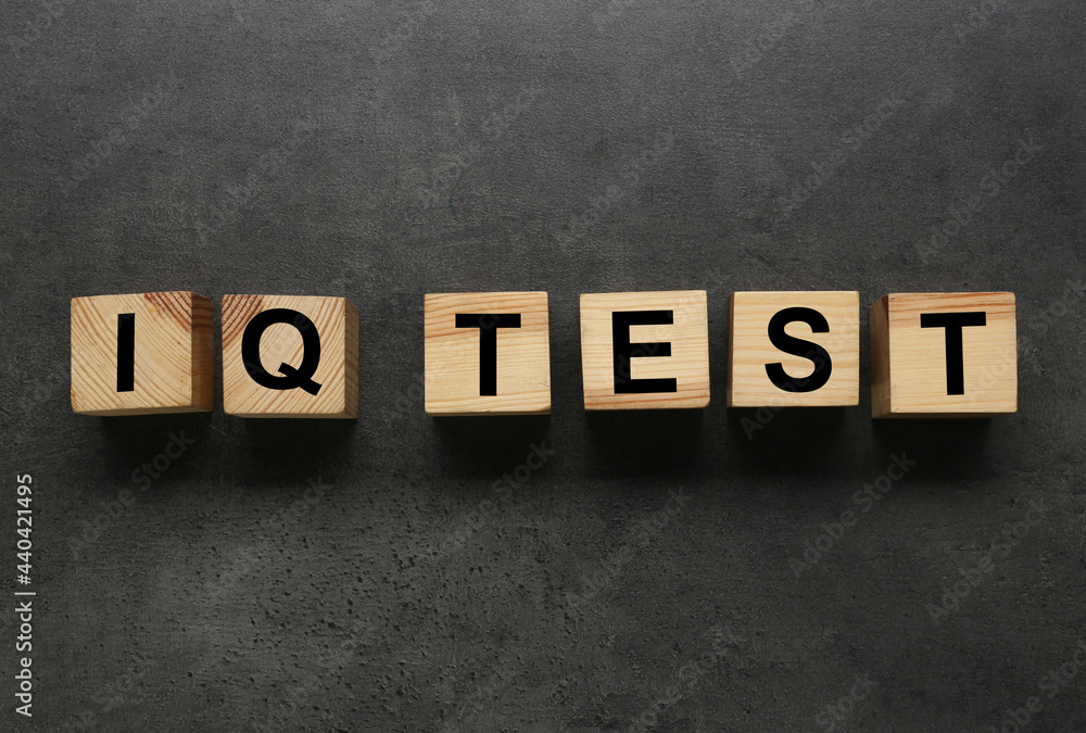Obraz premium Cubes with text IQ Test on grey background, flat lay