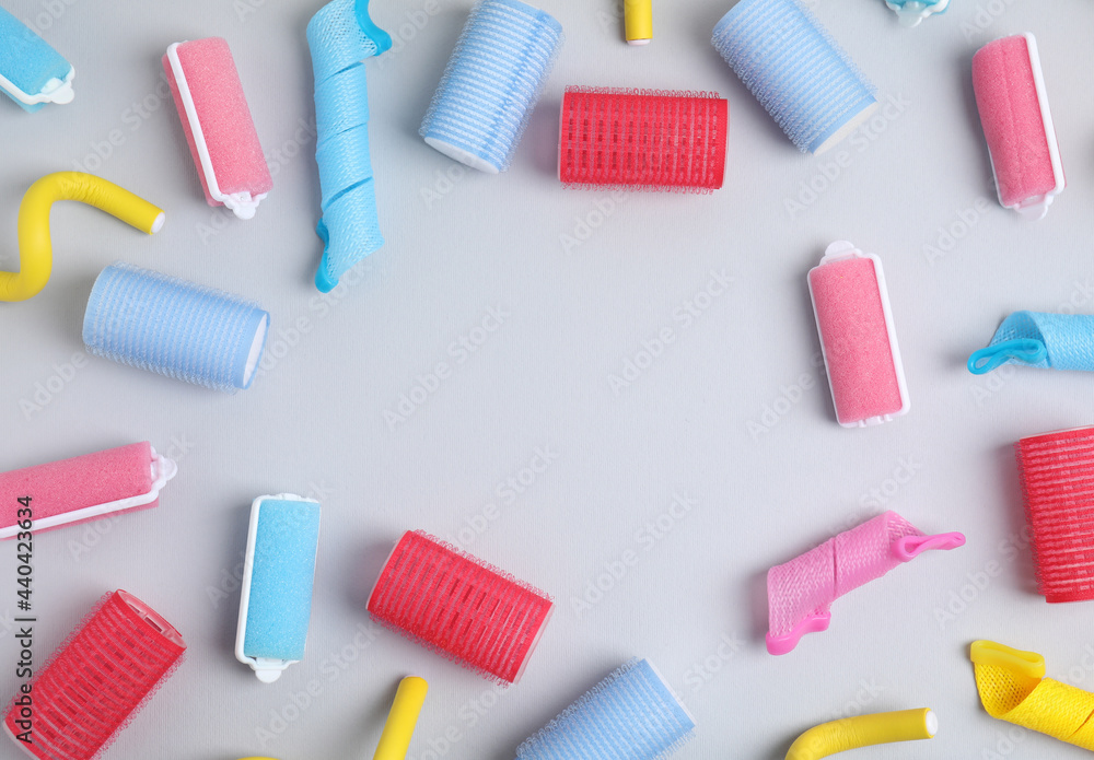 Frame of different hair curlers on light grey background, flat lay. Space for text Frame of different hair curlers on light grey background, flat lay. Space for text