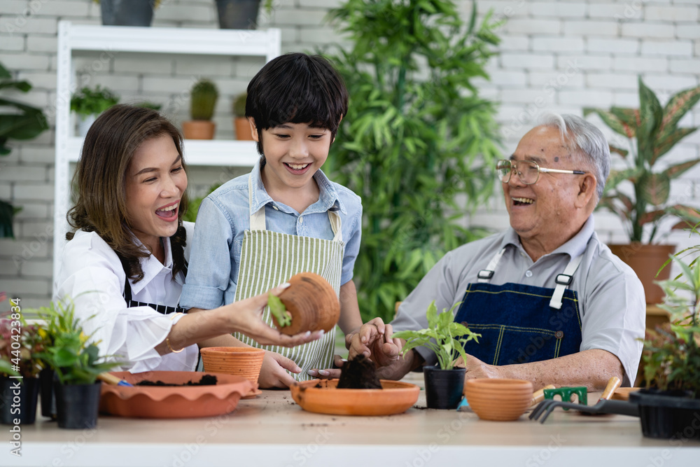 Happy family gardening together in the garden, grandfather grandson and woman taking care of nature Happy family gardening together in the garden, grandfather grandson and woman taking care of nature