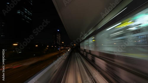 Automatic train move from tunnel to overground way, quick night time lapse shot, view from driver cabin. Modern driver-less automated guideway transit at Osaka city photo