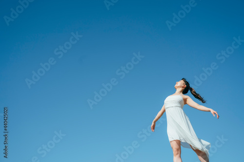 空と白いワンピースの踊る女性（深呼吸・全身） 