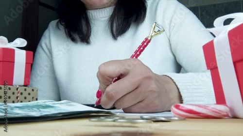 Christmas spending: Hand girl are calculate expenses for gifts at home, calculate expenses concept
