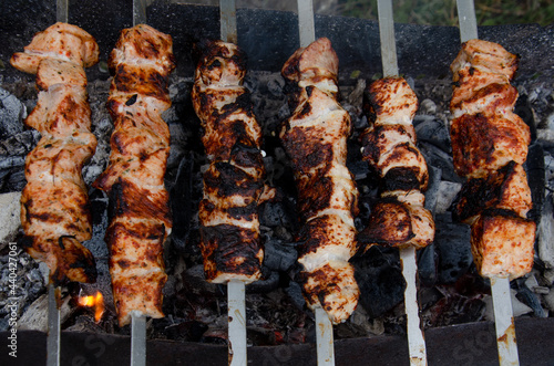 Shish kebab in the open air cooking process. The fried meat on the skewers is almost done. Coals in the grill