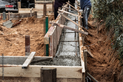 Timber formwork with metal reinforcement for pouring concrete and creating a solid foundation for a building or fence. Construction process photo