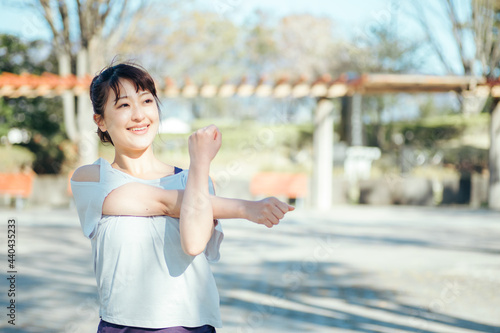 公園で準備運動する女性（腕）  © buritora