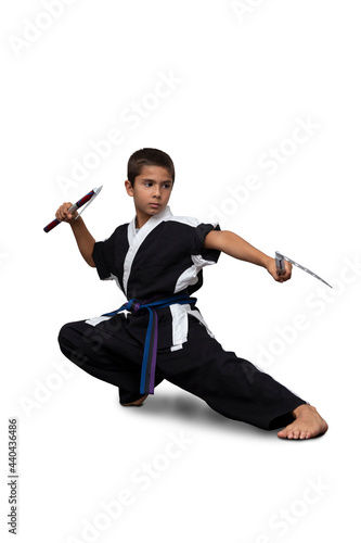 8 year old boy wearing a black martial arts kimono doing martial arts poses on a white background.