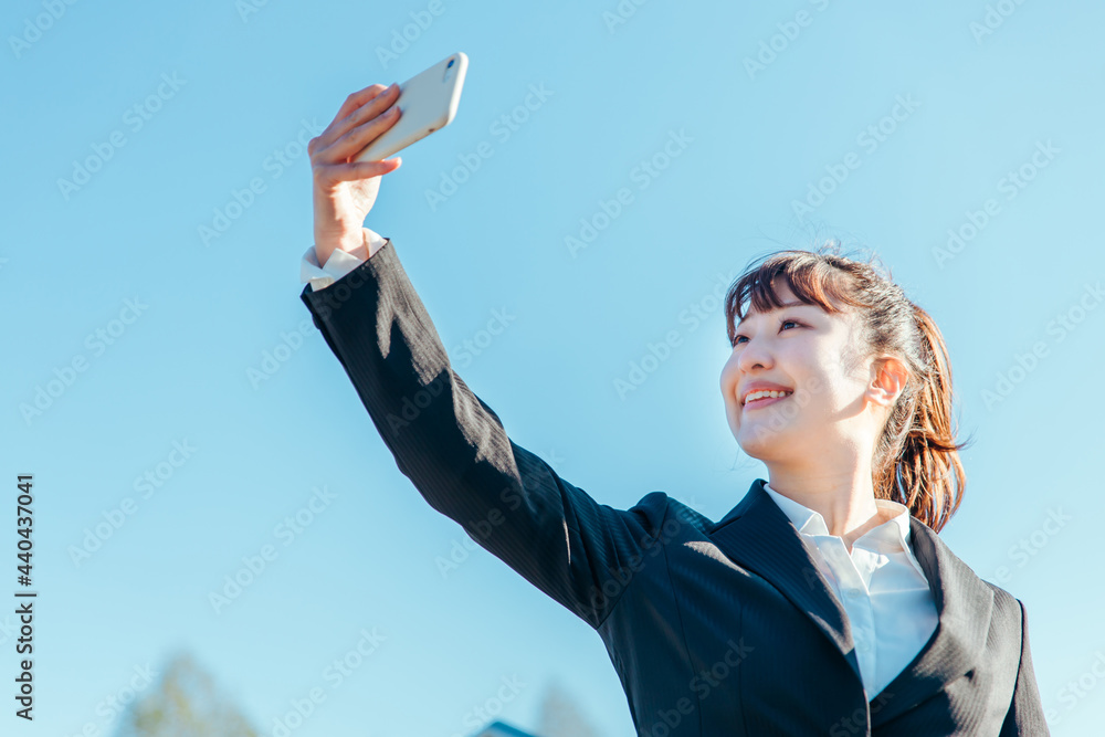 スマホをかざすビジネスウーマン(逆光)
スマホをかざすビジネスウーマン(逆光)