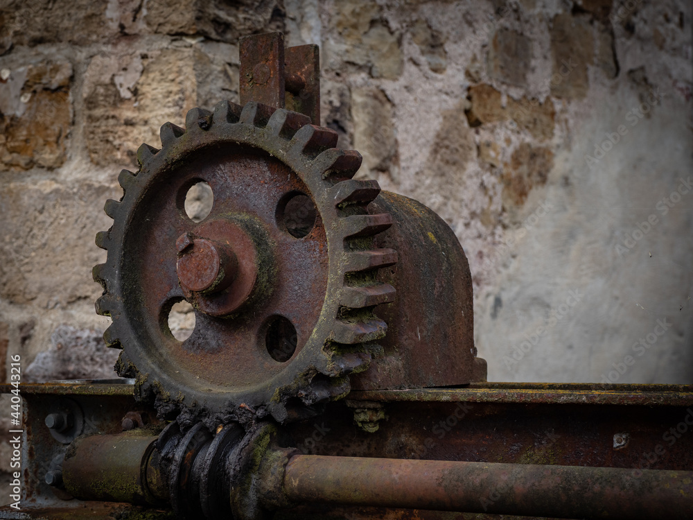 Pinion gear of vintage mechanism against old wall