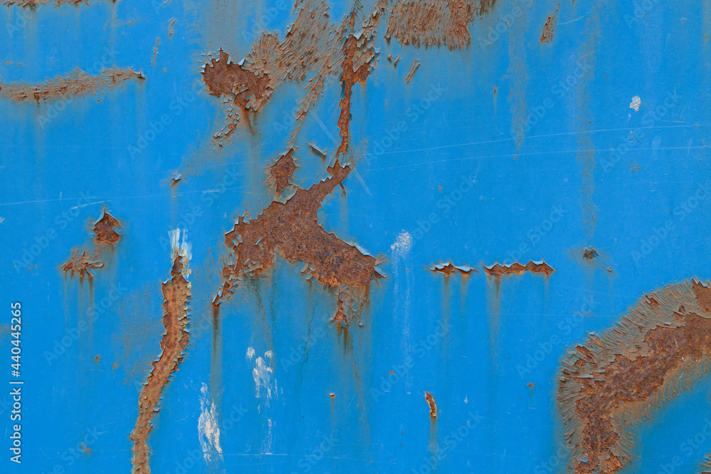 Close-up of a weathered sheet metal plate painted in blue. Paint is partly peeled off revealing rusty metal. High resolution full frame abstract background. Copy space. Close-up of a weathered sheet metal plate painted in blue. Paint is partly peeled off revealing rusty metal. High resolution full frame abstract background. Copy space.