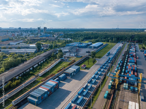 Multicolored freight containers at the railway customs. Aerial drone view.