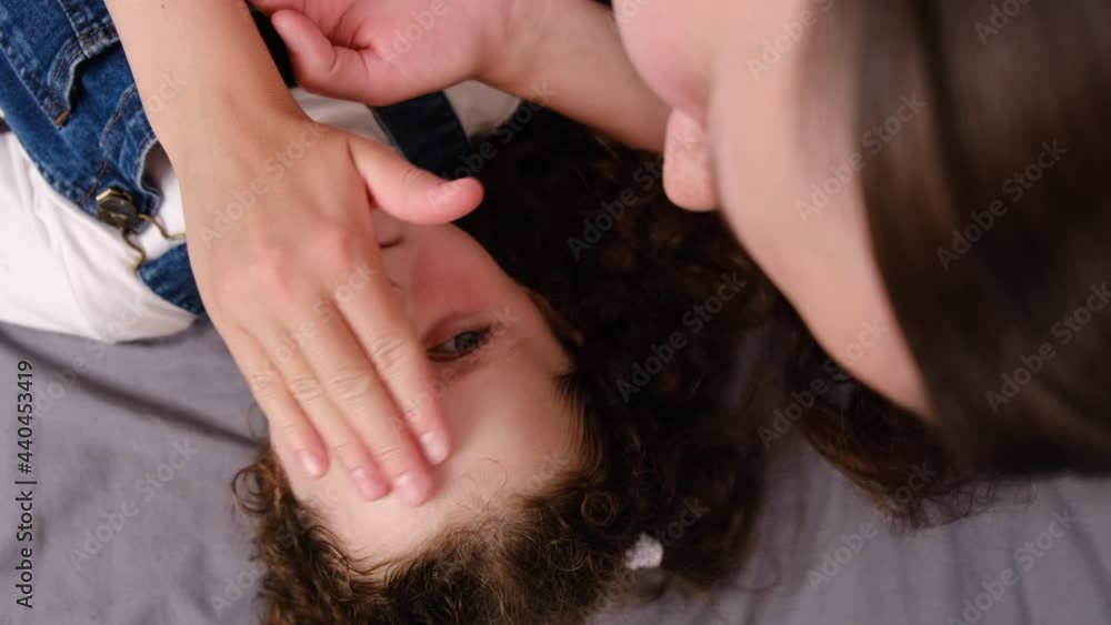 Allergic reaction, itch, dermatitis, dry skin concept. Top view close up of caring young brunette mom applying cream little preschooler daughter kid ointment on swollen skin against mosquito bites Allergic reaction, itch, dermatitis, dry skin concept. Top view close up of caring young brunette mom applying cream little preschooler daughter kid ointment on swollen skin against mosquito bites