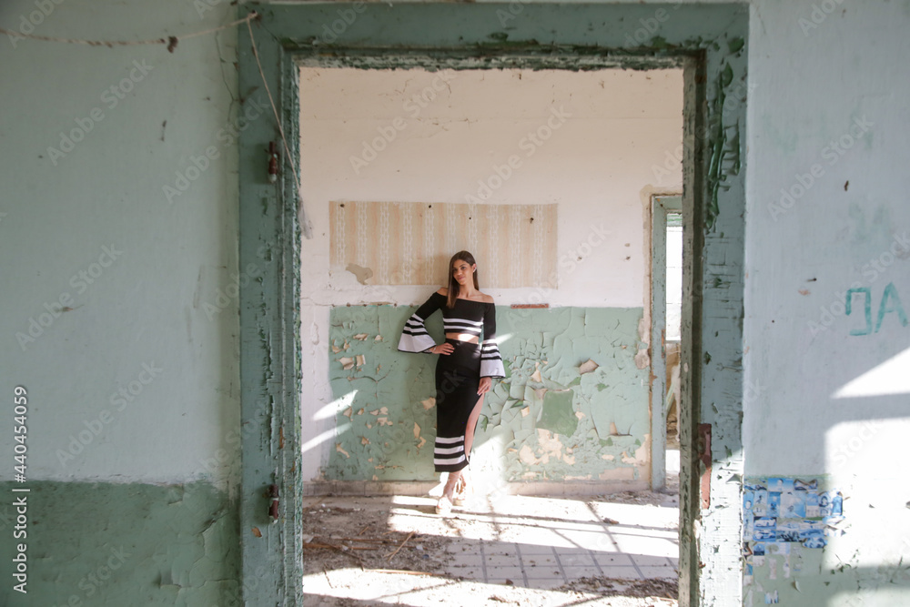 Portrait of gorgeous fashionable brunette girl in black and white outfit against old weathered wall Portrait of gorgeous fashionable brunette girl in black and white outfit against old weathered wall